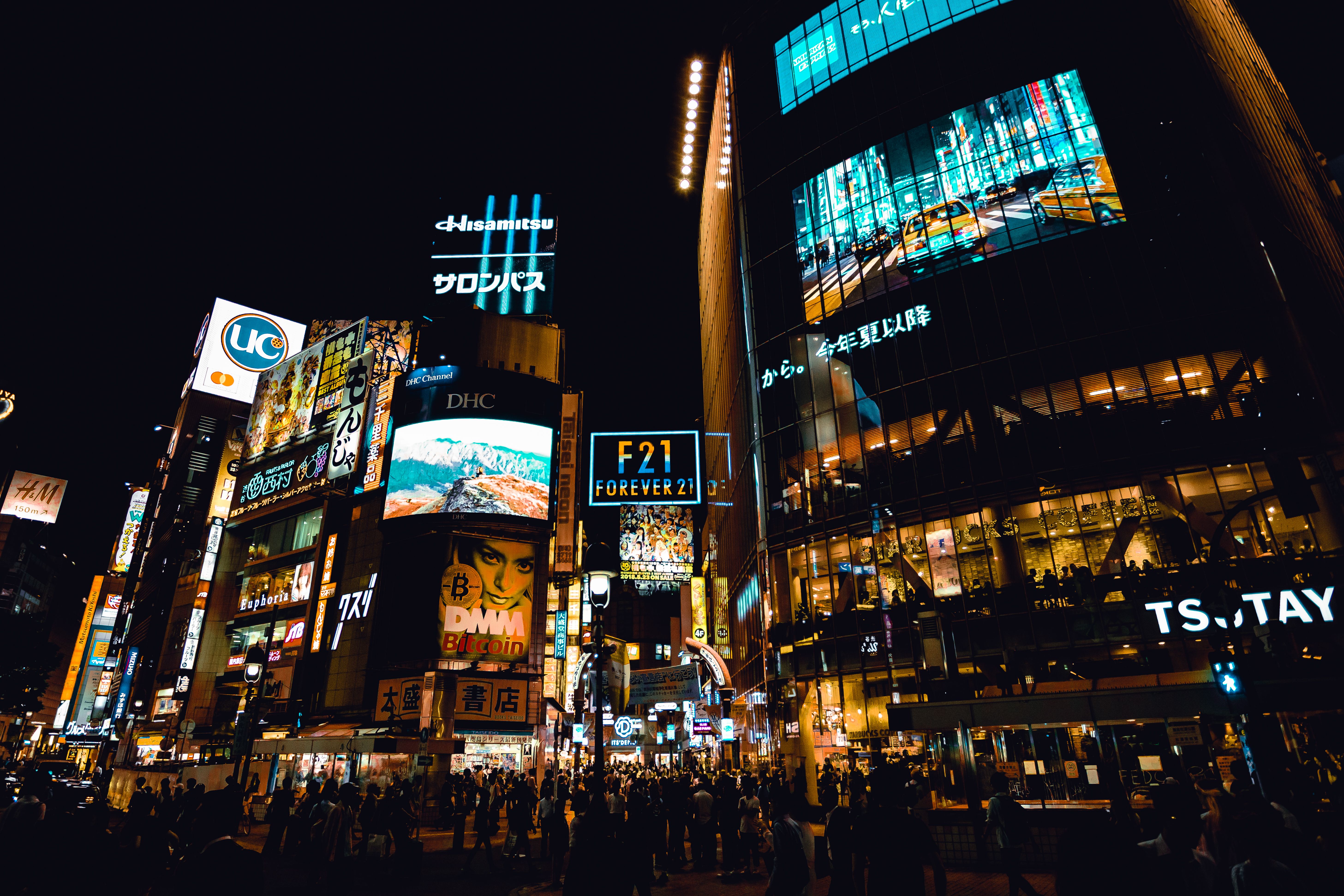Crowds cross Shibuya under vivid neon signs, showing Tokyo's energetic nightlife.
